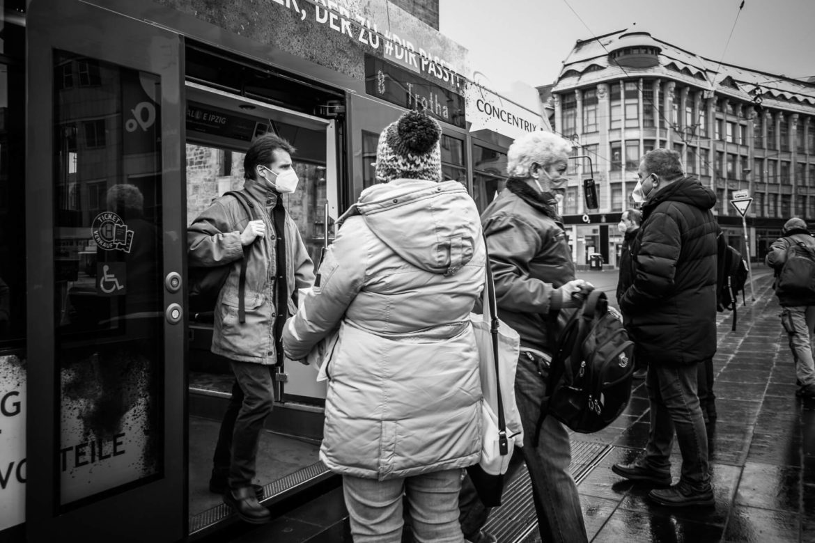 Menschen steigen in Straßenbahn ein und aus