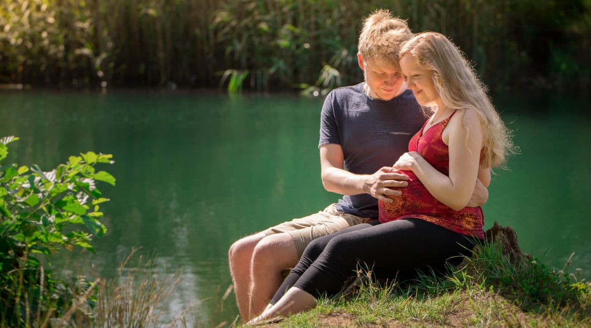 junges Paar beim Babybauch Fotoshooting in der Natur